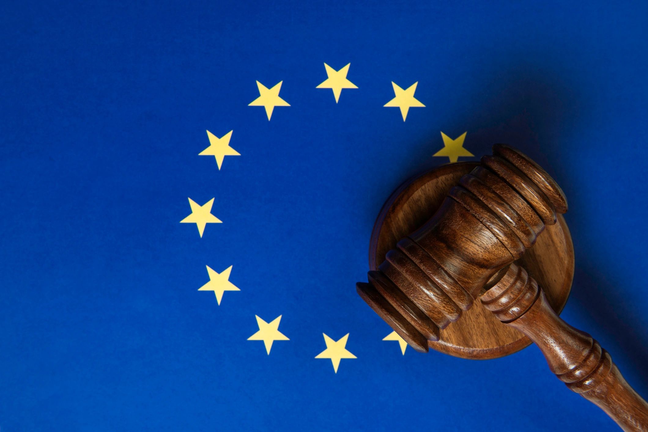 Martelletto e bandiera europea per rappresentare quadro normativo e condizioni legali